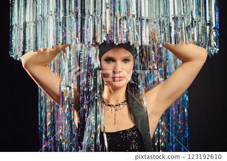 Elegant performer showcasing shimmering attire under sparkling light fixtures at a glamorous event 123192610