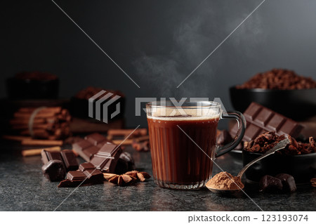 Glass mug of hot chocolate with ingredients on a black kitchen table. 123193074