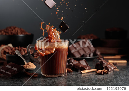 Pieces of dark chocolate fall into a mug of cocoa drink. Pieces of dark chocolate fall into a mug of cocoa drink. 123193076