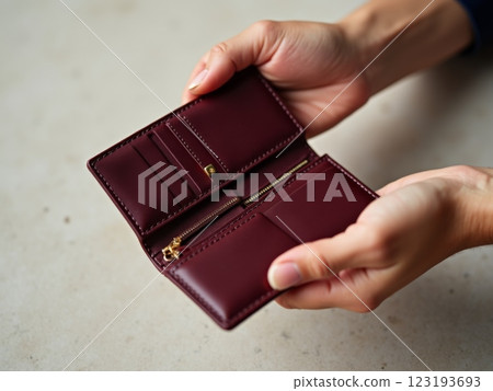 Elegant Feminine Hands Examining Designer Leather Wallet Against Polka Dot Background Elegant Feminine Hands Examining Designer Leather Wallet Against Polka Dot Background 123193693