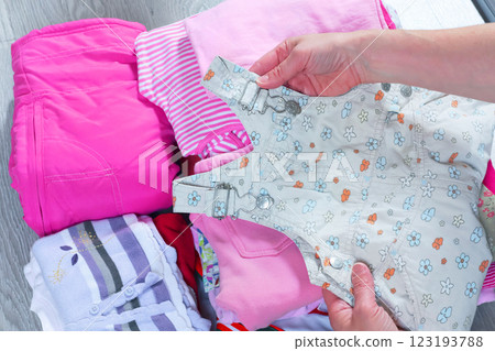 Woman put children clothes in stack. Cleaning and recycling. Ecology and upcycling. Woman put children clothes in stack. Cleaning and recycling. Ecology and upcycling. 123193788