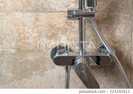 Clean faucet in shower stall on marble modern dark tile after cleaning. Cleanliness in the bathroom. Taking care of house and order. 123193813