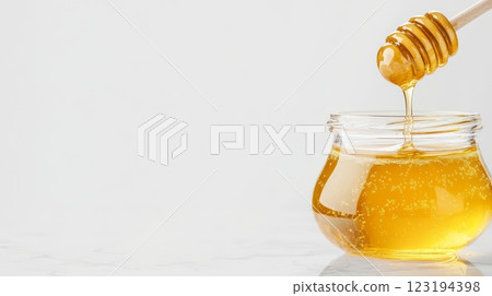 Sweet golden honey being drizzled into a glass jar Sweet golden honey being drizzled into a glass jar 123194398