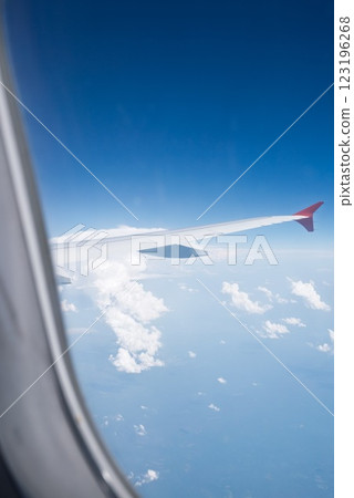 View from window of the plane above expanse of fluffy white clouds 123196268