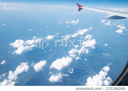 View from window of the plane above expanse of fluffy white clouds View from window of the plane above expanse of fluffy white clouds 123196269