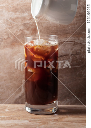 Iced coffee with cream on a beige ceramic table. 123196935