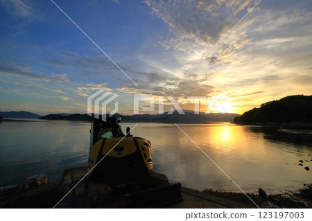A backhoe standing by the sea after work 123197003