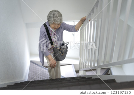 老年婦女抱著膝蓋爬樓梯 老年婦女抱著膝蓋爬樓梯 123197120