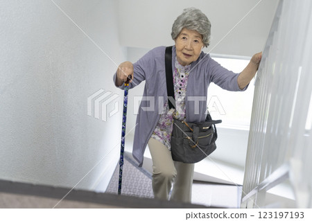 拄著拐杖走上樓梯的老年婦女 123197193