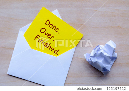 Top view of Done, Over and Finished text on yellow paper in an envelope. Resignation concept. 123197512