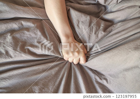 Close up of a person hand gripping grey wrinkled fabric with strength Close up of a person hand gripping grey wrinkled fabric with strength 123197955