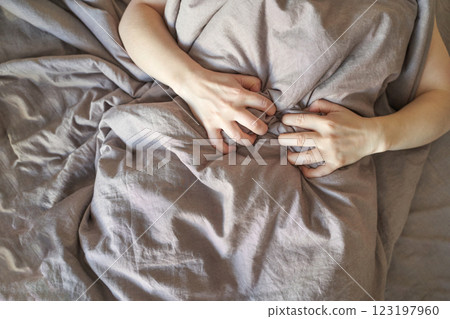 Caucasian adult female hands gripping grey blanket calm peaceful sleep restful 123197960