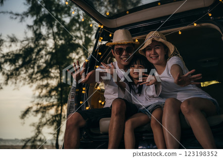 Asian family sitting back car to beach at sunset feeling funny in holidays and relaxation together. Dad, mom and daughter happy weekend travel enjoy at beach. summer vacation travel camping road trip Asian family sitting back car to beach at sunset feeling funny in holidays and relaxation together. Dad, mom and daughter happy weekend travel enjoy at beach. summer vacation travel camping road trip 123198352