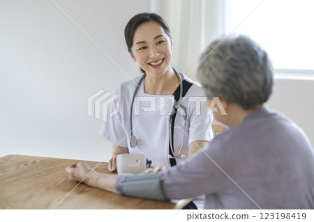 Nurse measuring blood pressure of a senior woman 123198419