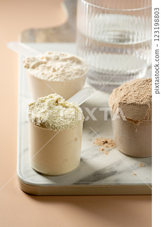 Protein powder in scoops. Different flavours of whey protein powders 123198803