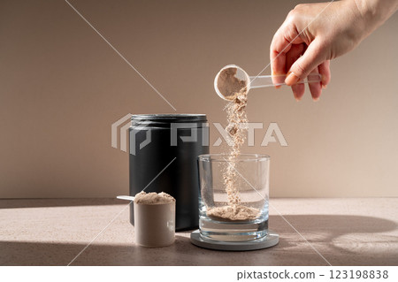 Chocolate protein powder in a scoop, food supplement 123198838