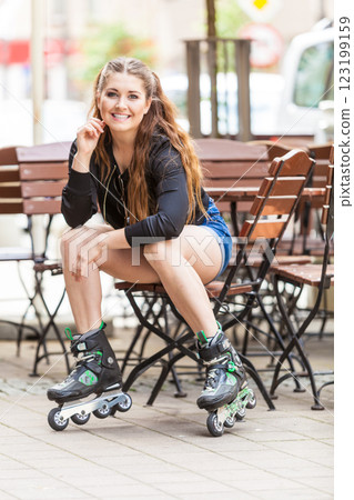Young woman sitting wearing roller skates 123199159