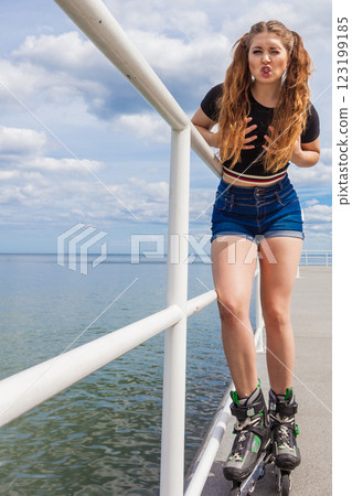 Joyful teen girl wearing roller skates 123199185