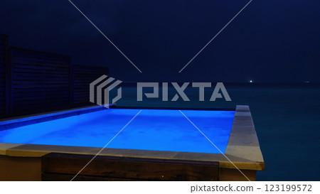 Infinity pool overlooking the ocean at night with blue lighting Infinity pool overlooking the ocean at night with blue lighting 123199572