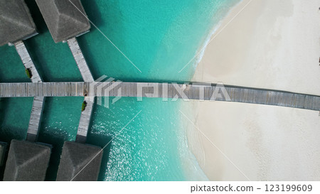 Wooden pier connecting overwater bungalows to the white sand beach 123199609