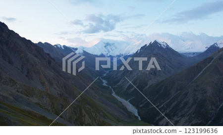 Breathtaking view of snow-capped mountains and winding river at dawn in the tien shan range 123199636