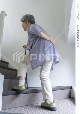 老年婦女抱著腰爬樓梯 老年婦女抱著腰爬樓梯 123200052