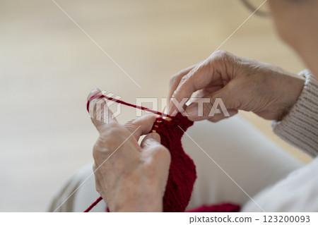 Hands of a senior woman knitting 123200093