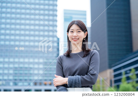 A woman smiling with a building in the background 123200804