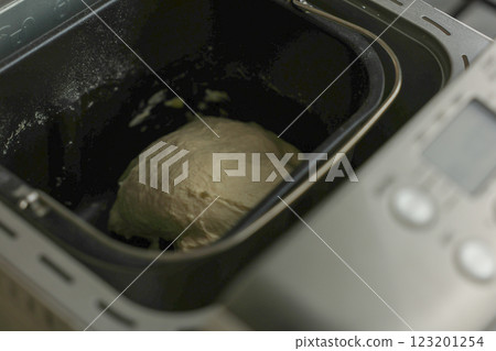 In the black bowl of the automatic bread machine there is dough, you can see the cooking panel. The concept of kneading dough, making bread. High quality photo 123201254