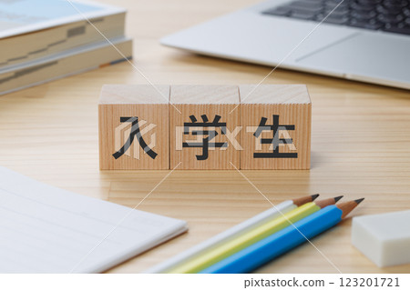 A block with the word "enrolled student" written on it on a desk 123201721