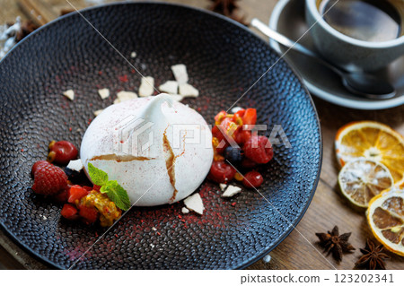 Pavlova berry cake with passion cream, strawberry, meringue. Delicious sweet dessert food closeup served for lunch in modern gourmet cuisine restaurant Pavlova berry cake with passion cream, strawberry, meringue. Delicious sweet dessert food closeup served for lunch in modern gourmet cuisine restaurant 123202341