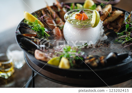 Exquisite seafood platter featuring grilled shrimp, mussels, octopus, and seared tuna, served with a smoky avocado mousse, fresh lemon, and microgreens. Perfect gourmet dish for seafood lovers Exquisite seafood platter featuring grilled shrimp, mussels, octopus, and seared tuna, served with a smoky avocado mousse, fresh lemon, and microgreens. Perfect gourmet dish for seafood lovers 123202415