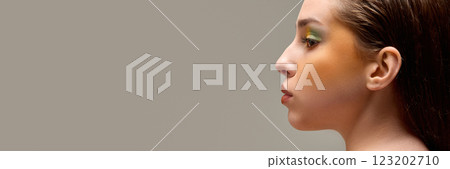 Banner. Extremely close-up of young woman with stylish, bright make-up against warm grey background with negative space to insert text. Banner. Extremely close-up of young woman with stylish, bright make-up against warm grey background with negative space to insert text. 123202710