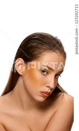 Artistic, creative portrait of young attractive woman with bright, colorful make-up looking at camera with confident expression against white studio background. Artistic, creative portrait of young attractive woman with bright, colorful make-up looking at camera with confident expression against white studio background. 123202713