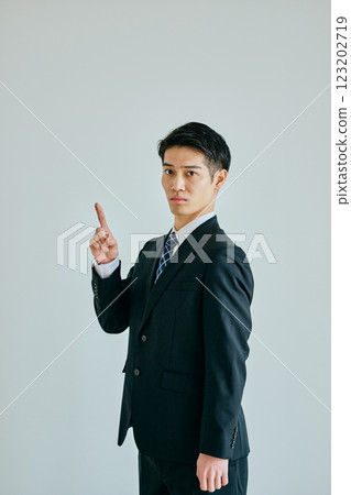 Young man pointing his index finger up Young man pointing his index finger up 123202719