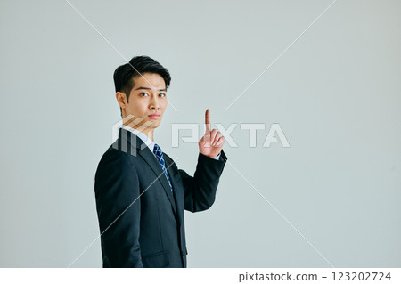 Young man pointing his index finger up Young man pointing his index finger up 123202724