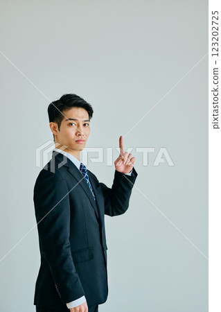 Young man pointing his index finger up Young man pointing his index finger up 123202725