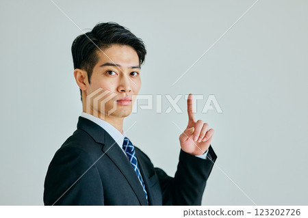 Young man pointing his index finger up Young man pointing his index finger up 123202726