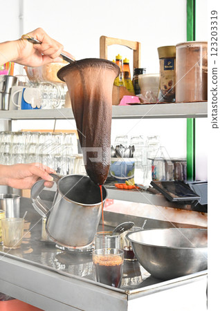 Kopi Tubruk is an local Asian style coffee. By pouring hot water over the fine coffee grounds and filtering them directly into the glass. Kopi Tubruk is an local Asian style coffee. By pouring hot water over the fine coffee grounds and filtering them directly into the glass. 123203319