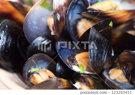 Boiled mussels in dish on dark wooden background close up Boiled mussels in dish on dark wooden background close up 123203451