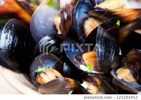 Boiled mussels in dish on dark wooden background close up Boiled mussels in dish on dark wooden background close up 123203452