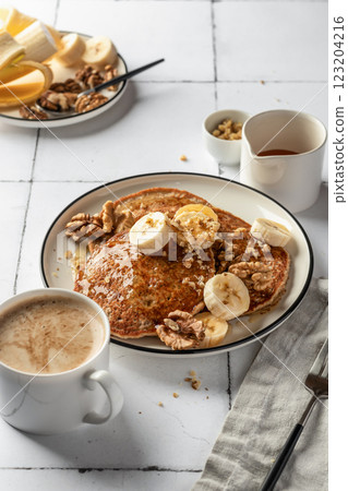 Healthy oatmeal pancakes with banana, nuts and honey on white tile background. Morning food breakfast concept. Pancake day or Maslenitsa recipe 123204216