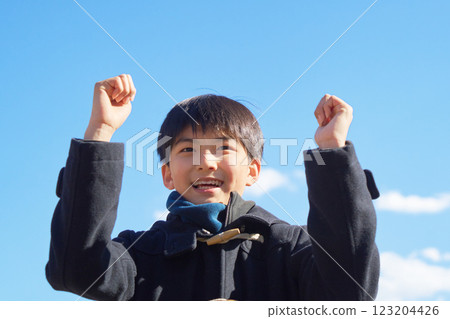 一個男孩在藍天下握拳擺姿勢 123204426