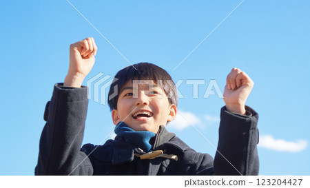 一個男孩在藍天下握拳擺姿勢 123204427