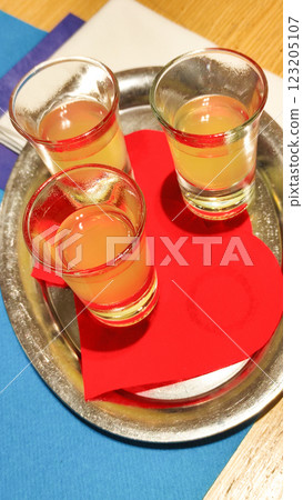 Limoncello glasses resting on silver tray with red napkin, capturing bright italian refreshment in bibione seaside setting 123205107