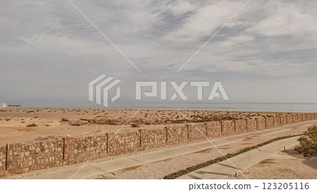 Stone wall separating resort from sandy beach in marsa alam, egypt 123205116