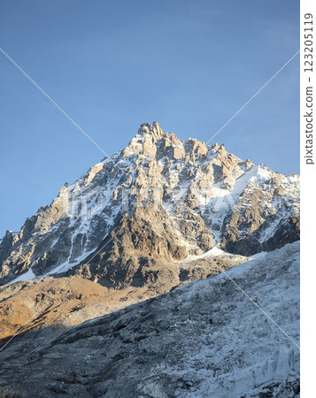 Aiguille du midi majestic peak Mont Blanc looming over chamonix valley in autumn 123205119