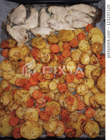 Chicken breast slicing, with seasoned potatoes, parsley root, carrots, dinner on rustic baking sheet easy dinner 123205120