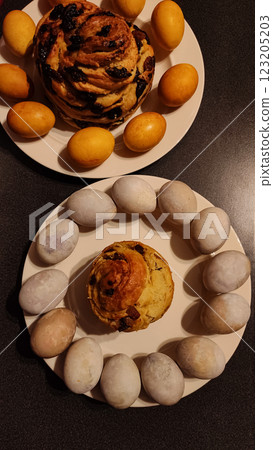 Traditional easter cakes resting near pastel violet carcade and golden onion skin colored naturally dyed eggs, showcasing festive holiday baking and culinary celebration Traditional easter cakes resting near pastel violet carcade and golden onion skin colored naturally dyed eggs, showcasing festive holiday baking and culinary celebration 123205203