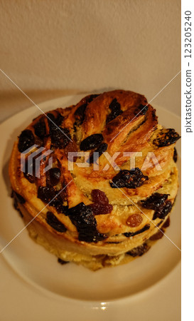 Traditional easter bread sprinkled with raisins, candied fruit, nestled on white ceramic plate, showcasing festive holiday baking copy space Traditional easter bread sprinkled with raisins, candied fruit, nestled on white ceramic plate, showcasing festive holiday baking copy space 123205240